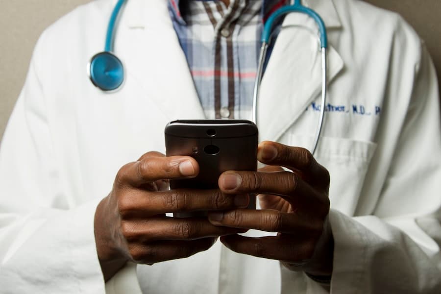 Clinician typing daily care notes on a smartphone